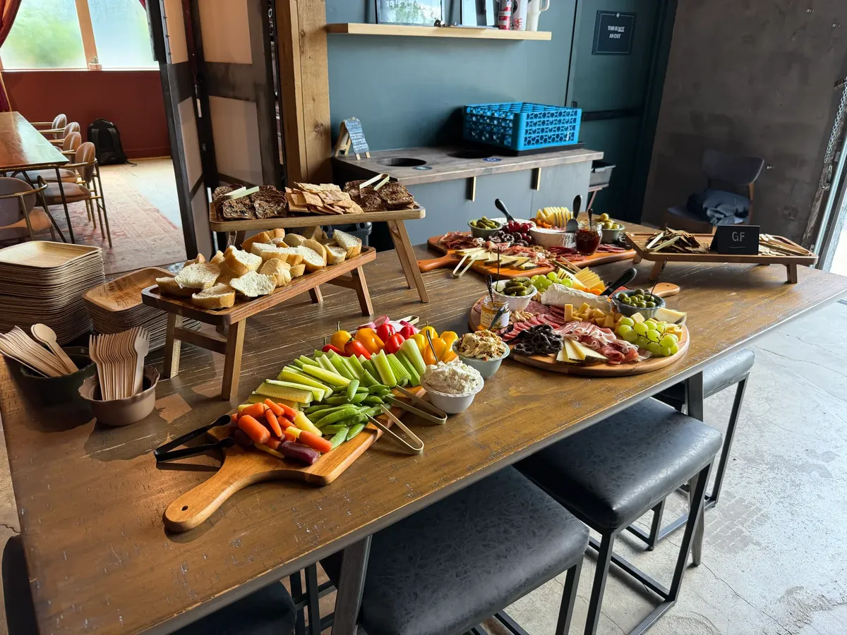 Grazing table of charcuterie boards, cheeses, and fresh crudités set up at a Denver event
