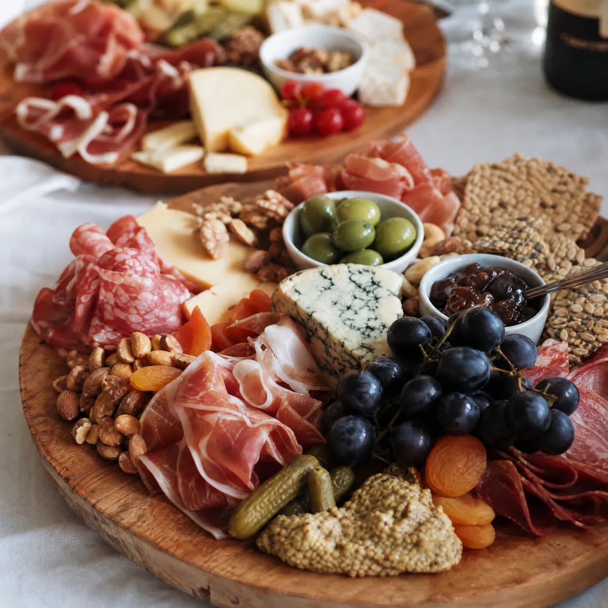 Overhead charcuterie board with salami, blue cheese, grapes, and preserves